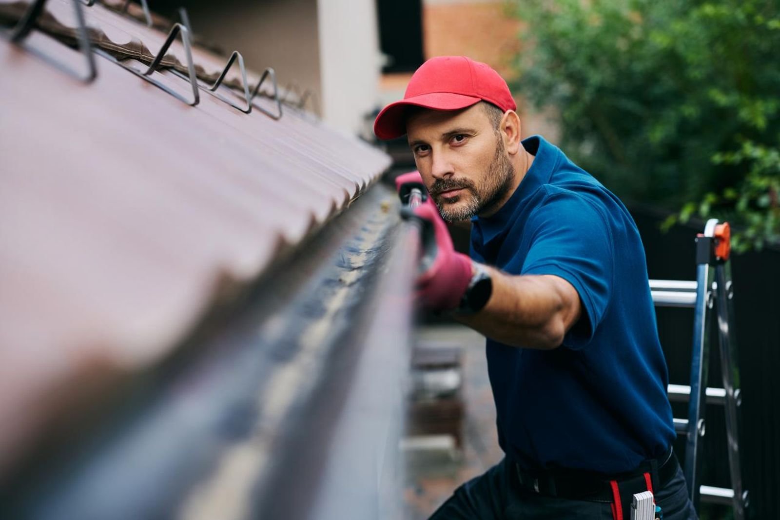 Contractor re-hanging and re-levelling a sagging gutter